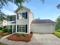 Traditional two-story home featuring a two-car garage, driveway, and lush landscaping at 4311 Marci St, Snellville, GA 30039