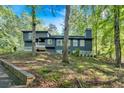 Beautiful two-story home nestled on a wooded lot, featuring dark siding and surrounded by trees at 510 Watergate Ct, Roswell, GA 30076