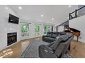 Bright living room with a fireplace, hardwood floors, a leather sofa, and large windows at 510 Watergate Ct, Roswell, GA 30076