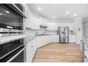 Bright kitchen with modern stainless steel appliances, white cabinets, a center island, and stylish lighting at 307 Cochin Dr, Woodstock, GA 30188