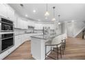 Spacious kitchen featuring stainless steel appliances, white cabinets, granite countertops, and a central island with bar seating at 307 Cochin Dr, Woodstock, GA 30188