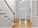 Bright foyer with hardwood floors, staircase, and a view of the front door at 4915 Lazy Creek Ct, Cumming, GA 30028