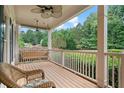 Inviting covered front porch with a wooden swing, ceiling fan and comfortable seating at 4915 Lazy Creek Ct, Cumming, GA 30028