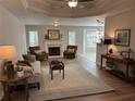Bright living room with fireplace, tray ceiling, neutral colors, and lots of windows at 1221 St James Pl, Loganville, GA 30052