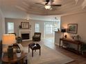 Bright living room with fireplace, tray ceiling, neutral colors, and lots of windows at 1221 St James Pl, Loganville, GA 30052
