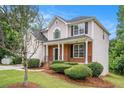 View of a two-story home with brick and siding, professionally landscaped lawn at 2681 Lakeside Sw Dr, Conyers, GA 30094