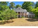 Traditional brick home showcasing mature trees, with a beautifully landscaped front yard at 2595 Winthrope Way, Lawrenceville, GA 30044