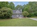 Charming home featuring a classic covered front porch and well-maintained landscaping at 402 Wood Chase Ln, Canton, GA 30114