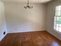 Cozy dining room with hardwood floors, chandelier lighting, and a large window at 2703 Arrowood Dr, East Point, GA 30344