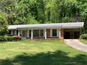 Charming brick home featuring a covered porch, large windows, and a well-manicured front yard at 2703 Arrowood Dr, East Point, GA 30344