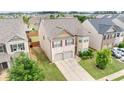 Aerial view of a two-story home with a two-car garage and lush, green landscaping at 556 Emporia Loop, Mcdonough, GA 30253