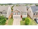 An aerial view of a two-story home with an attached two-car garage and manicured landscaping at 556 Emporia Loop, Mcdonough, GA 30253