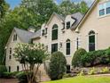Elegant home showcasing a beautiful entrance, lush greenery, and a striking façade with a grand staircase at 5940 Plantation Dr, Roswell, GA 30075