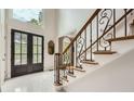 Inviting foyer with soaring ceilings, marble floor, and a staircase featuring decorative wrought iron at 5940 Plantation Dr, Roswell, GA 30075