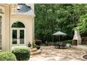 A serene outdoor patio with dining set and outdoor fireplace, perfect for entertaining and enjoying nature at 5940 Plantation Dr, Roswell, GA 30075