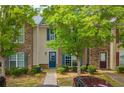 Inviting townhouse with stone and siding accents, blue door, and mature trees in a well-kept community at 1851 Grove Way, Hampton, GA 30228