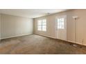 Cozy living room with neutral walls, carpet flooring, and a back door leading to outdoor space at 1851 Grove Way, Hampton, GA 30228