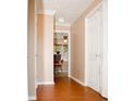 Hallway with tan walls, white trim, and wood floors leading to the kitchen at 2592 King Louis Ne Rd, Conyers, GA 30012