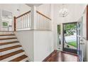 Inviting entryway with hardwood floors, stairs with wooden railing, and natural light streaming through a large front door at 4096 Audubon Dr, Marietta, GA 30068