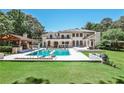 Luxurious backyard features a sparkling pool, covered outdoor kitchen, and expansive green space perfect for entertaining at 4309 Sentinel Post Nw Rd, Atlanta, GA 30327