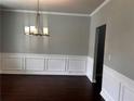 Dining room featuring wood floors, decorative wainscoting, and a modern chandelier at 2363 Bear Mountain St, Lithonia, GA 30058