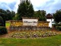 Stone entrance sign for Mason's Mill Estates with landscaping and colorful flowers at 2363 Bear Mountain St, Lithonia, GA 30058
