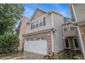 Side view of charming two-story townhome with attached two-car garage and landscaped yard at 1684 Tailmore Ln, Lawrenceville, GA 30043