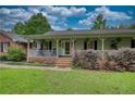 Lovely home featuring an inviting covered front porch, a brick walkway, and a beautifully landscaped yard at 78 N Pomona Rd, Hampton, GA 30228