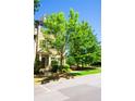 Brick townhouse with covered front door entrance, landscaping, and green trees under a blue sky at 1420 Baygreen Rd, Suwanee, GA 30024
