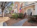 Charming two-story home with brick accents, an American flag, and well-maintained landscaping at 220 Riverview Trl, Roswell, GA 30075