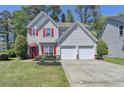 Charming two-story home with a well-manicured lawn, red door, red shutters, and attached two-car garage at 2477 Lakebrooke Dr, Marietta, GA 30066