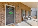 Covered front porch with brick facade and seating area at 440 S Alexander St, Buford, GA 30518