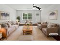 Staged living room featuring ample seating, plush rug, natural light, and neutral color palette at 1886 Akron Se Dr, Atlanta, GA 30315