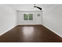 Bright, unstaged living room with hardwood floors and a large window that brings in natural light at 1886 Akron Se Dr, Atlanta, GA 30315