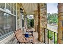 Inviting front porch features stone pillars, comfortable seating, and a peaceful view of the surrounding neighborhood at 221 Thompson St, Alpharetta, GA 30009