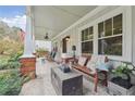 Inviting covered front porch with tiled floors, comfortable seating and backyard views at 4442 Mclain Cir, Acworth, GA 30101