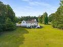 Expansive backyard showcasing a white home with a deck, surrounded by lush greenery and trees at 692 Brooks Woolsey Rd, Brooks, GA 30205