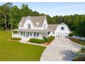 Beautiful white farmhouse with a wide porch, attached garage, and spacious driveway at 692 Brooks Woolsey Rd, Brooks, GA 30205