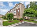Attractive townhome featuring stone accents, attached garage, and manicured front lawn at 893 Society Sw Cir, Atlanta, GA 30331
