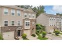 Well-maintained townhome featuring stone and siding exterior, attached garage and landscaped yard at 893 Society Sw Cir, Atlanta, GA 30331