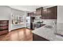Modern kitchen with stainless steel appliances, granite countertops, and dark wood cabinets at 893 Society Sw Cir, Atlanta, GA 30331
