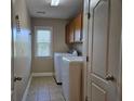 Well-lit laundry room with tile flooring, washer, dryer, and built-in cabinetry for storage at 3623 Terrah Point Dr, Duluth, GA 30097
