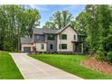 Well-manicured lawn and tasteful landscaping accentuates this modern two-story home with a three-car garage at 130 Nova Ln, Roswell, GA 30075