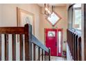 Bright foyer featuring a red front door, tile floor, and a staircase leading to the upper level at 317 Hoofbeat Ne Trl, Kennesaw, GA 30144