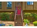 View of the front door with a red finish, decorative wreath, and wooden steps leading to the entrance at 317 Hoofbeat Ne Trl, Kennesaw, GA 30144
