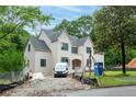An elegant two-story home with light brick facade, black-framed windows, and a well-manicured lawn, nestled among lush trees at 4608 Kings Down Rd, Atlanta, GA 30338