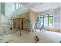 Under construction, a spacious living room with high ceilings, large windows, and staircase, bathed in natural light at 4608 Kings Down Rd, Atlanta, GA 30338