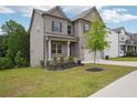 Beautiful home with green lawn, with a gray brick and siding exterior, complemented by a well-maintained landscape at 106 Logan Pass Dr, Loganville, GA 30052