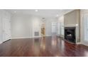 Open-concept living room with hardwood floors, fireplace, and view into kitchen through doorway and dining area at 175 15Th Ne St # 410, Atlanta, GA 30309