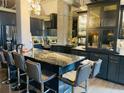 Modern kitchen featuring dark cabinets, a striking marble countertop island, and stainless steel appliances at 3180 Mathieson Drive # 502, Atlanta, GA 30305